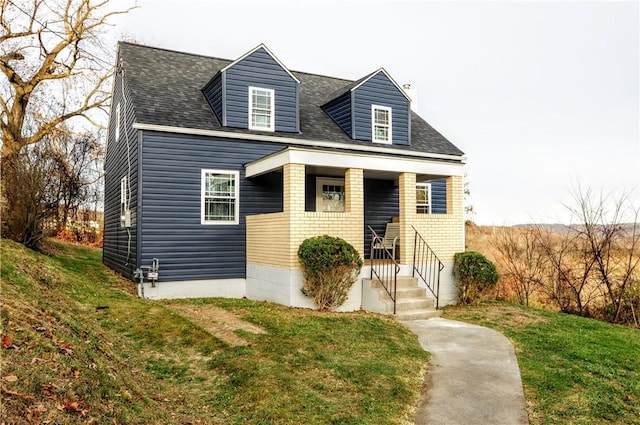 cape cod home featuring a front lawn