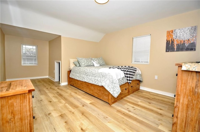 bedroom featuring light hardwood / wood-style floors and vaulted ceiling