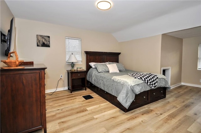 bedroom featuring lofted ceiling and light hardwood / wood-style flooring