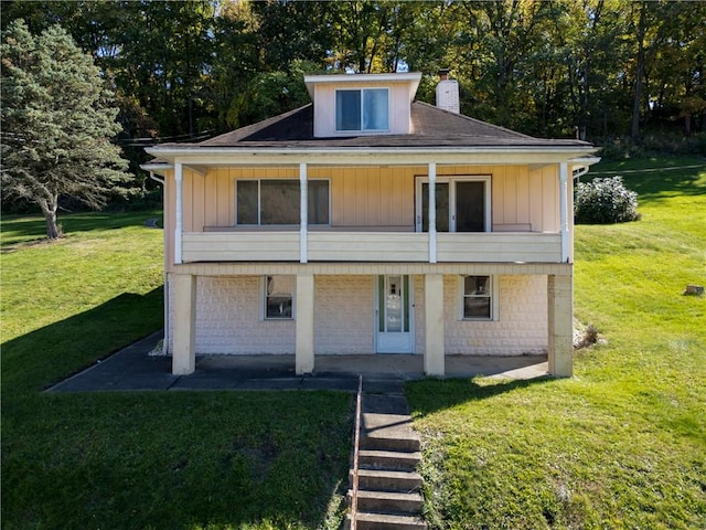 rear view of property with a yard