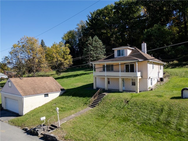 view of side of property with a lawn, a garage, and a balcony