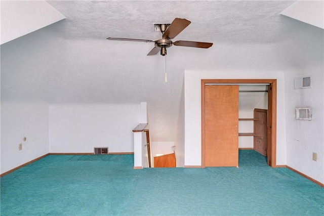 additional living space with lofted ceiling, ceiling fan, carpet, and a textured ceiling