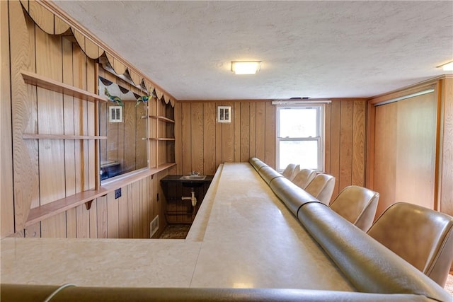 interior space featuring wooden walls and a textured ceiling