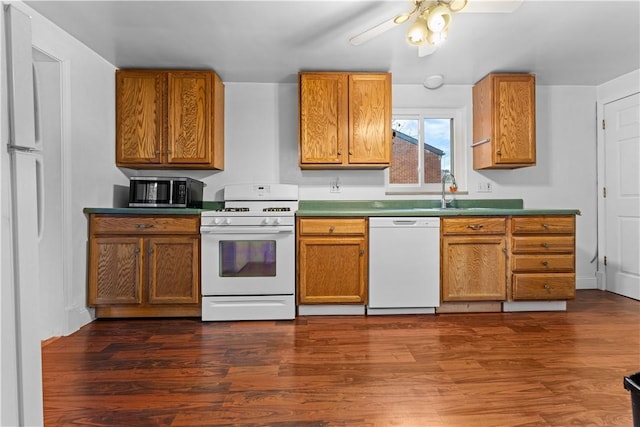 kitchen with sink, white appliances, dark hardwood / wood-style floors, and ceiling fan