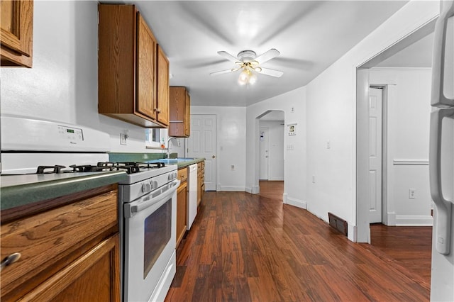 kitchen featuring ceiling fan, white appliances, dark hardwood / wood-style flooring, and sink