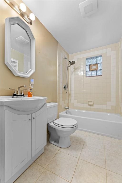 full bathroom with tile patterned flooring, vanity, tiled shower / bath combo, and toilet