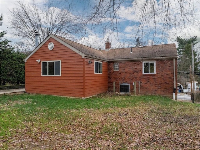 back of house featuring central AC and a lawn