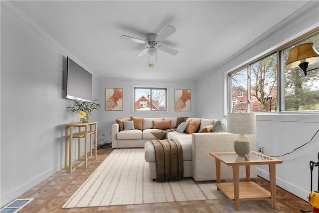 living room featuring crown molding, ceiling fan, and light parquet flooring