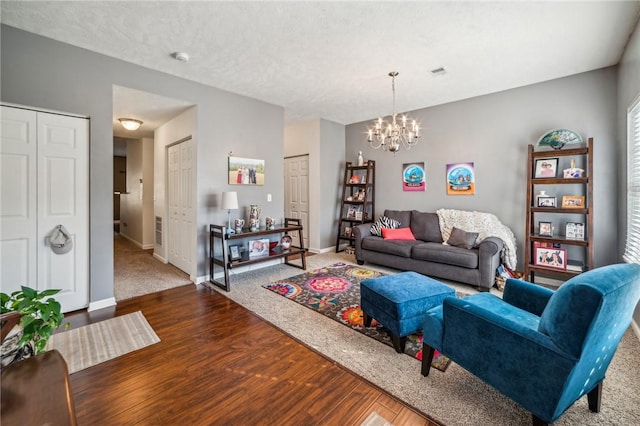 living room featuring wood-type flooring, a textured ceiling, and a chandelier