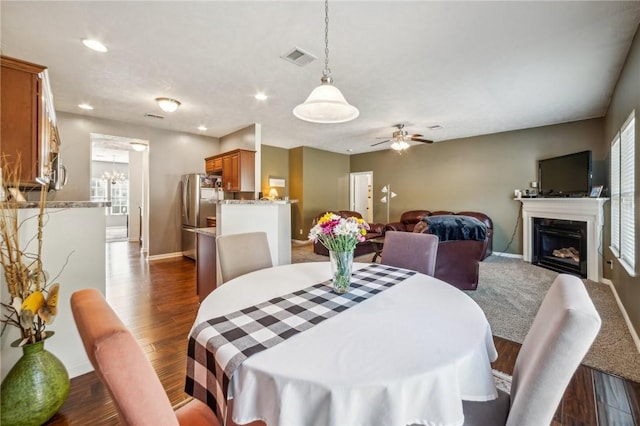 dining area with ceiling fan and dark wood-type flooring