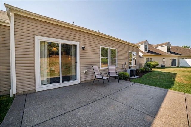 rear view of property with a lawn, a patio, and central AC unit