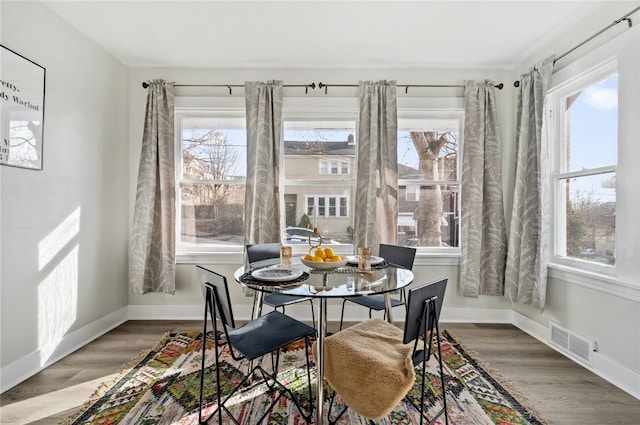 dining room featuring wood-type flooring and plenty of natural light