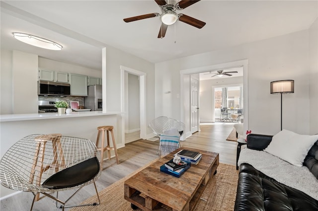 living room with light wood-type flooring and ceiling fan