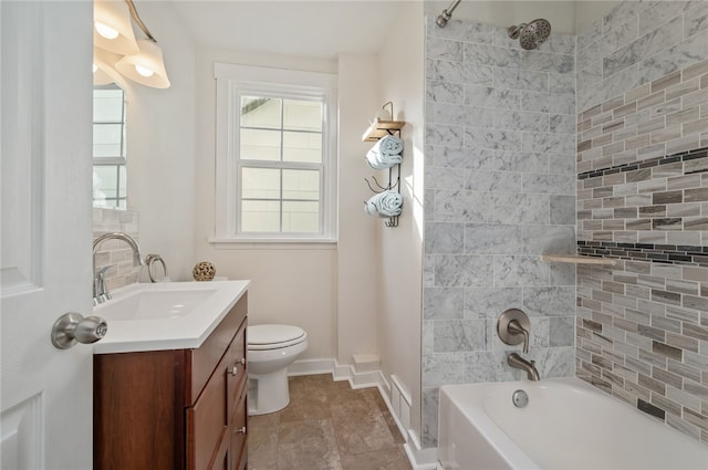 full bathroom featuring tiled shower / bath, vanity, and toilet