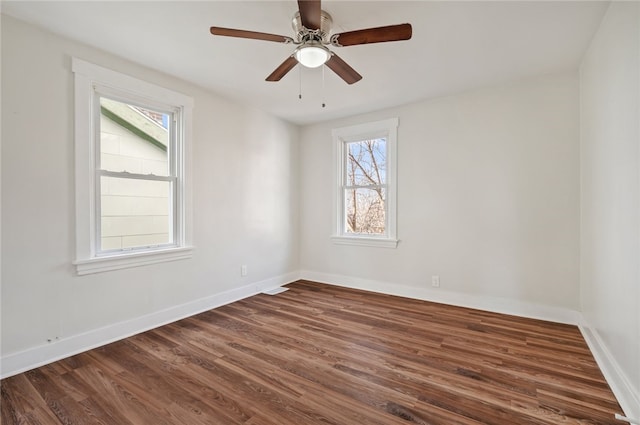 empty room featuring dark hardwood / wood-style flooring, a wealth of natural light, and ceiling fan