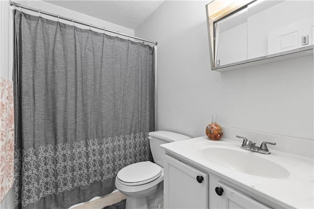 bathroom with vanity, curtained shower, and toilet