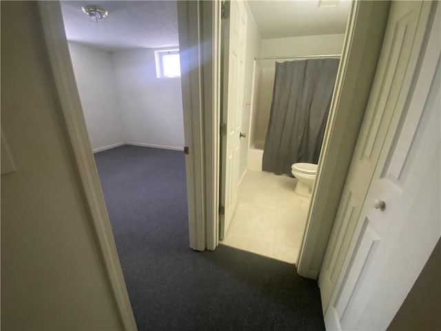 hall with dark colored carpet