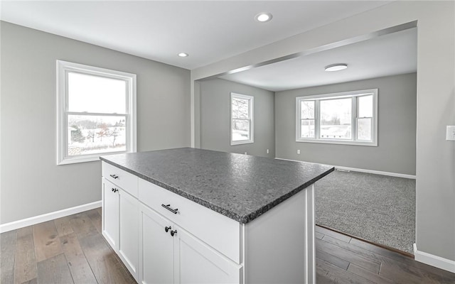 kitchen featuring a kitchen island, dark hardwood / wood-style flooring, and white cabinetry