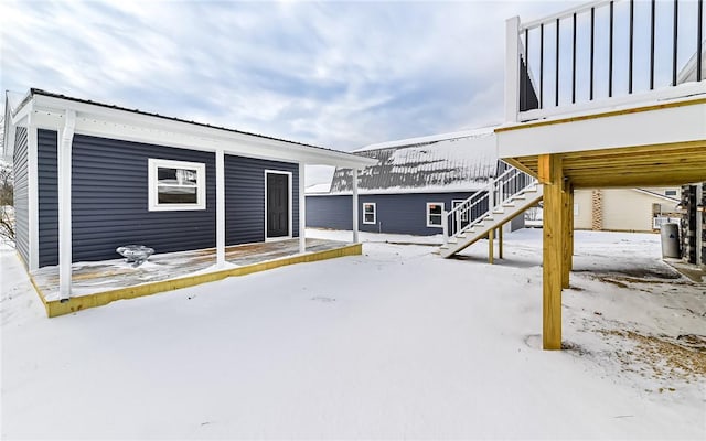 snow covered patio featuring a deck