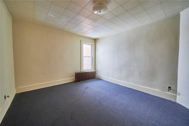 carpeted empty room featuring radiator heating unit