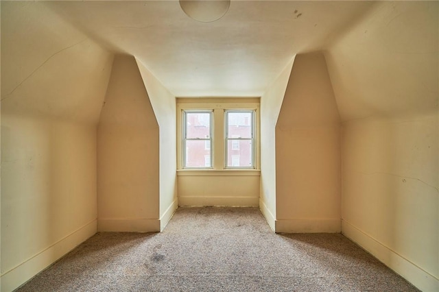 additional living space featuring carpet and lofted ceiling