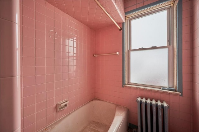 bathroom with a healthy amount of sunlight, radiator, and bathtub / shower combination