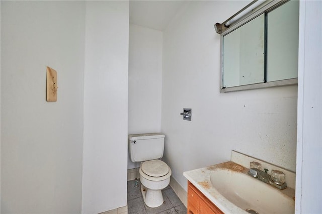 bathroom with tile patterned flooring, vanity, and toilet