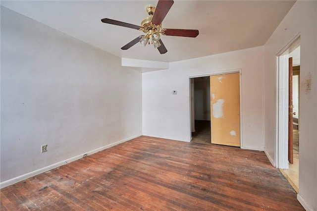 spare room featuring ceiling fan and dark wood-type flooring