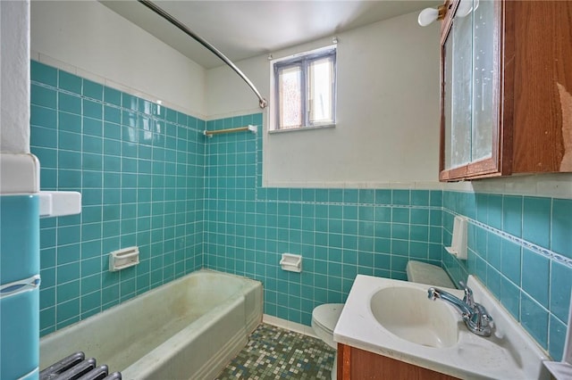 full bathroom featuring toilet, vanity, tile walls, and washtub / shower combination