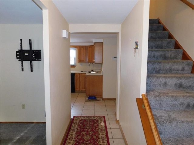 stairs with tile patterned floors and sink