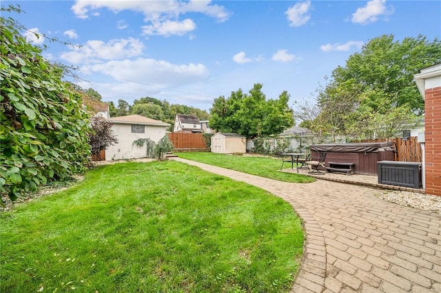 view of yard featuring a storage unit, a patio area, and a hot tub