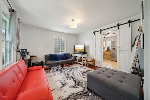 living room with a barn door and crown molding