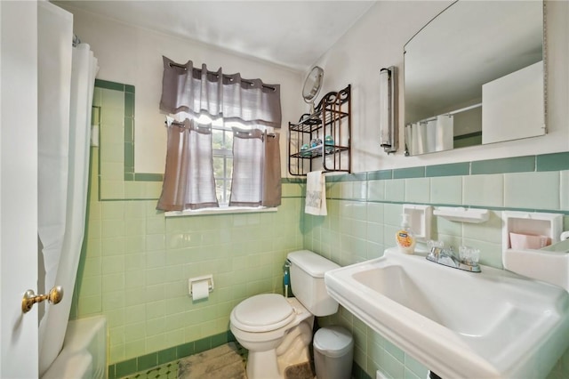 bathroom featuring toilet, tile walls, and sink