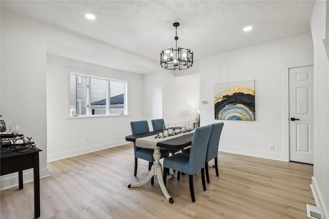 dining space with a chandelier and light wood-type flooring