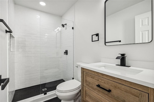 bathroom featuring tiled shower, vanity, and toilet