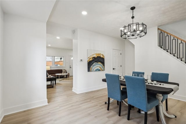 dining space featuring light hardwood / wood-style flooring and a chandelier