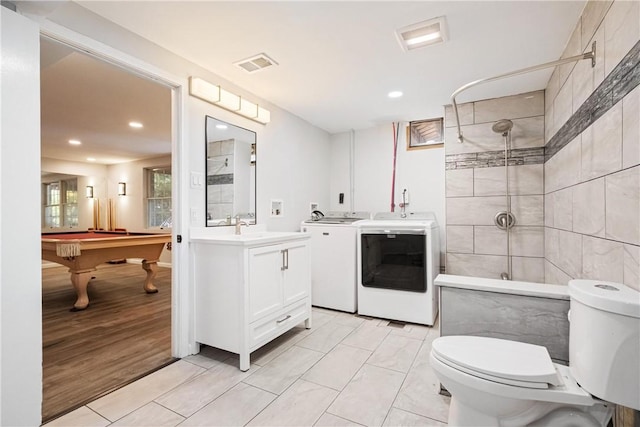 bathroom with washing machine and clothes dryer, tile patterned flooring, toilet, vanity, and pool table