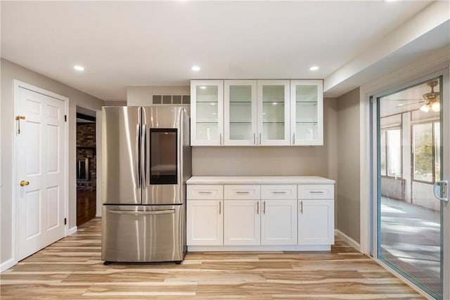 kitchen with stainless steel refrigerator, white cabinetry, light hardwood / wood-style flooring, and ceiling fan