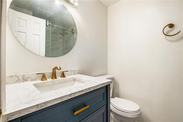 bathroom featuring vanity, toilet, and a shower with door