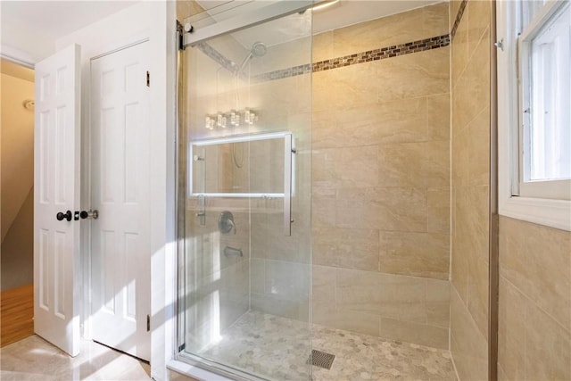 bathroom featuring a shower with shower door