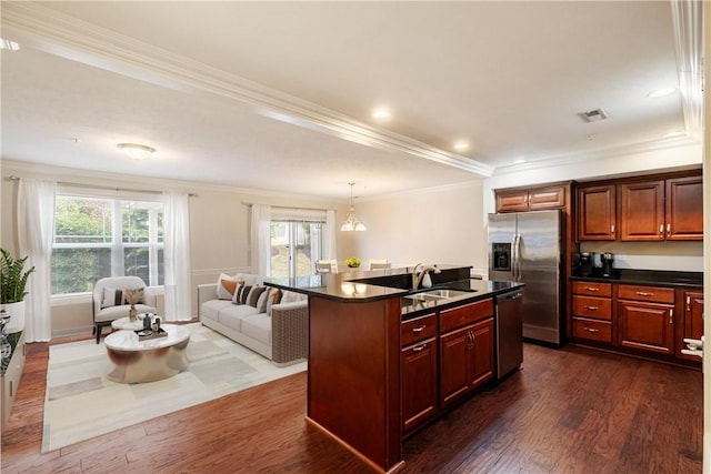 kitchen featuring sink, stainless steel appliances, dark hardwood / wood-style floors, crown molding, and a kitchen island with sink