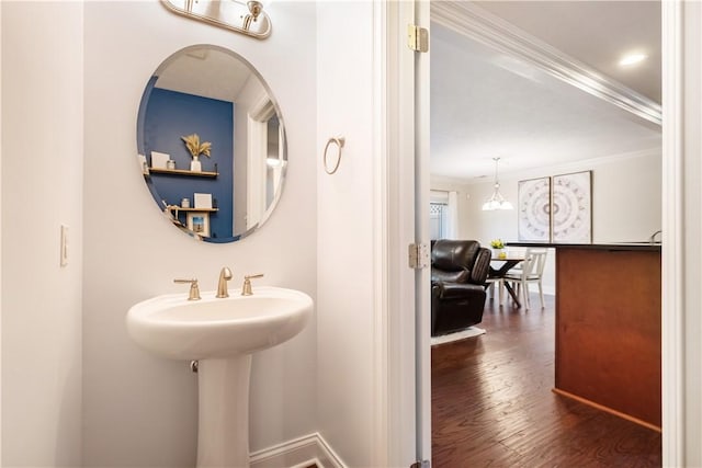 bathroom featuring hardwood / wood-style flooring, a notable chandelier, and ornamental molding