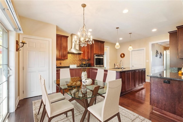 dining area featuring dark hardwood / wood-style floors, an inviting chandelier, and sink