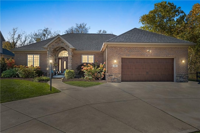 ranch-style home with a garage and a yard