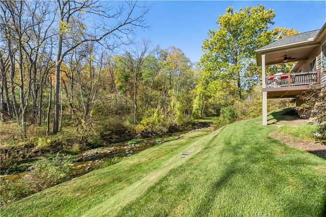 view of yard featuring ceiling fan and a wooden deck