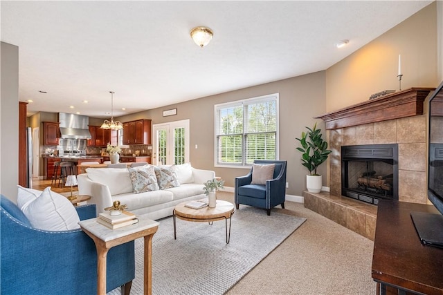 carpeted living room with a tile fireplace