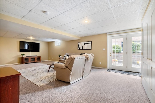 living room featuring carpet floors and a paneled ceiling