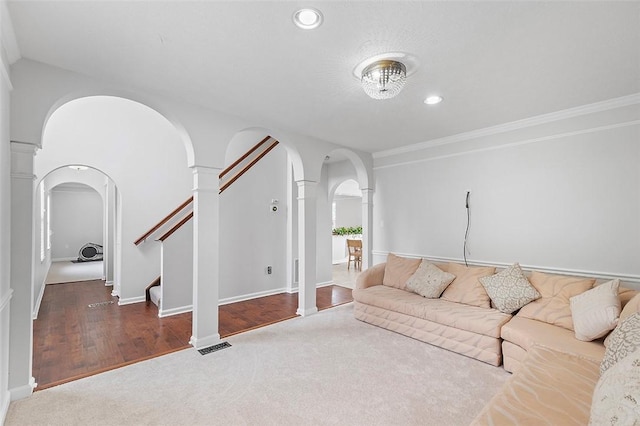 living room with dark hardwood / wood-style flooring, ornamental molding, and decorative columns