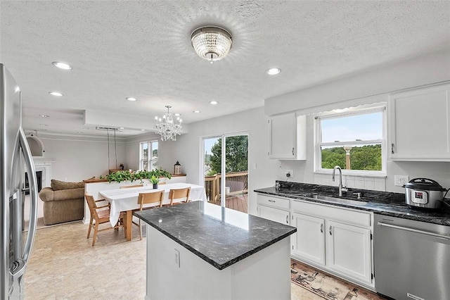 kitchen featuring pendant lighting, a center island, white cabinets, sink, and stainless steel appliances