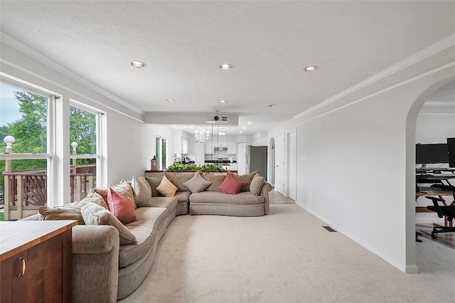 living room featuring light colored carpet, an inviting chandelier, and ornamental molding